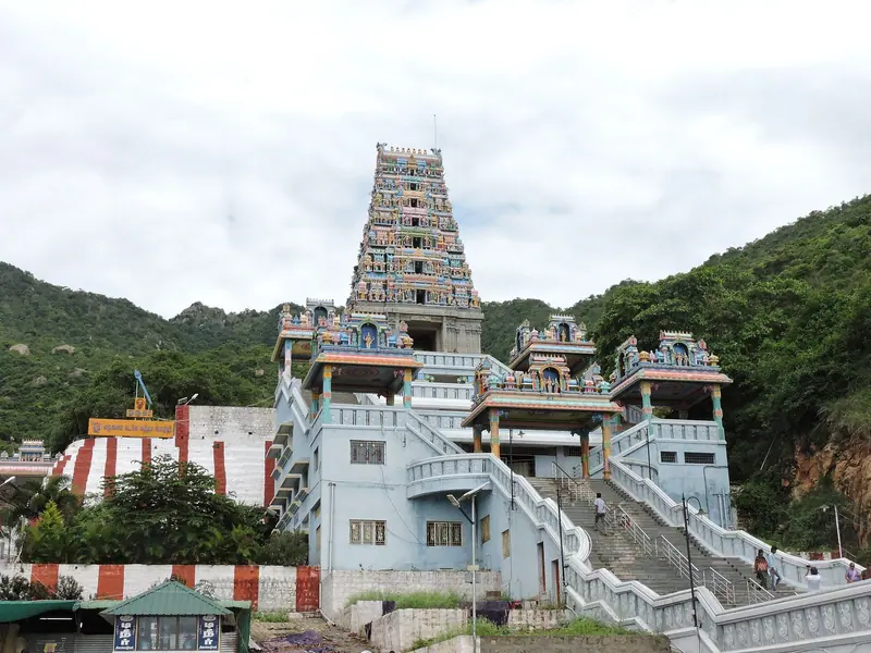 A temple tower and white halls on a green hillside