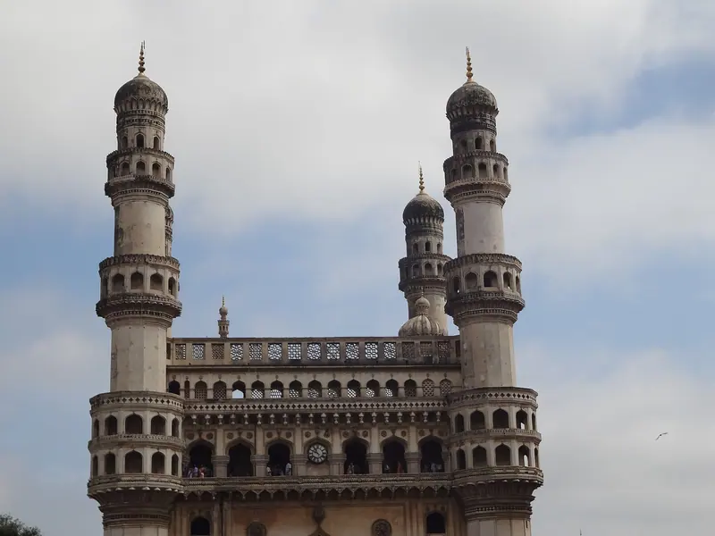 The four minarets of the Charminar against a cloudy sky