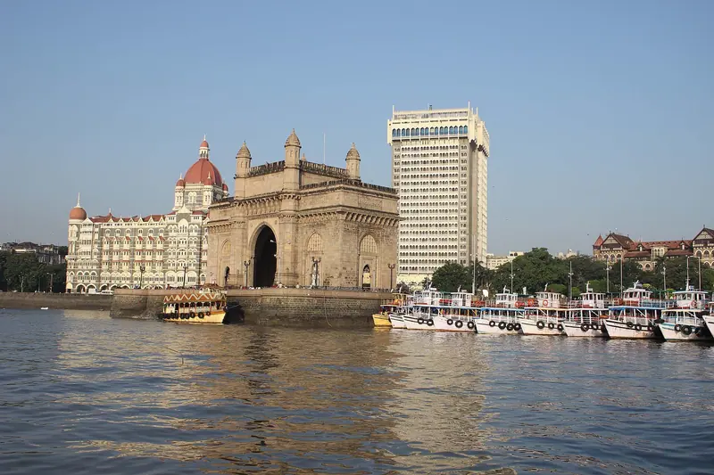 The Gateway of India arch and the Taj hotel seen across the water, ferries in front