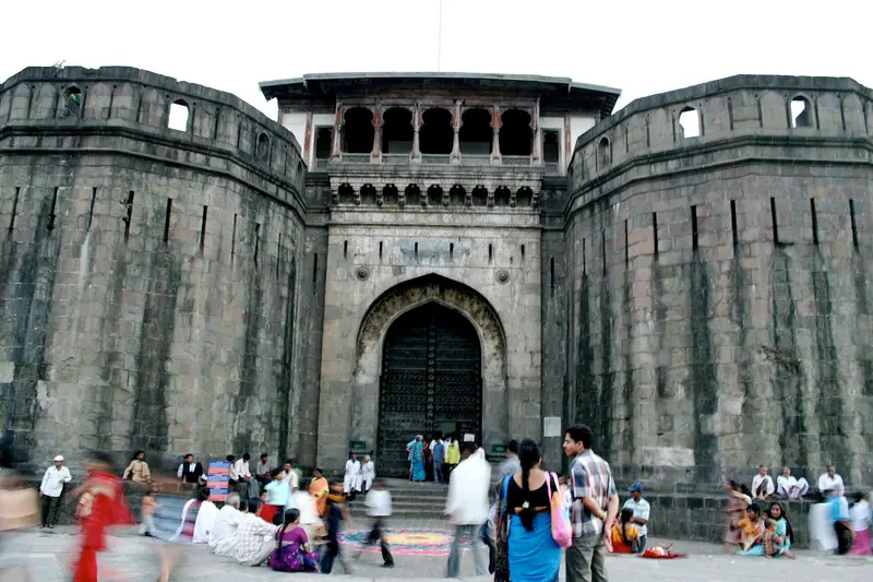 The stone walls and gate of Shaniwar Wada with visitors in front